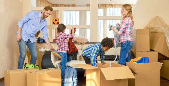 Family unpacking things from boxes. Kids and parents indoors. Pros and cons of renting.